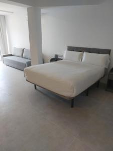 a bed with pillows and a couch in a room at Apartamento Nuevo Ondina in Begur