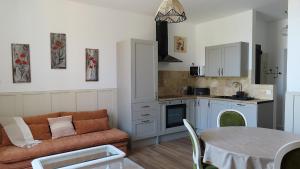 a kitchen and living room with a couch and a table at Les échappées de Senonches in Senonches