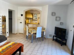 Una sala de estar con una mesa y un televisor. en Jolie T2 à 5 minutes de la mer, en Le Pradet 4 fotos más