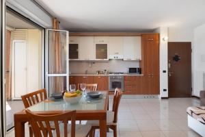 a kitchen and dining room with a table and chairs at Elegant Terrace Flat Parking near Rho Fiera Mi in Milan