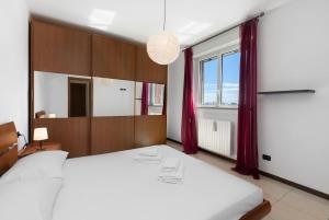 a bedroom with a large white bed and a window at Elegant Terrace Flat Parking near Rho Fiera Mi in Milan