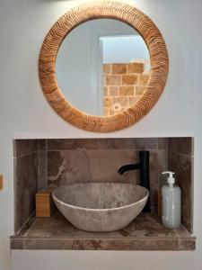 a bathroom sink with a large stone bowl and a mirror at T2 Cosy Clim & WiFi - Ecusson cœur de Montpellier in Montpellier