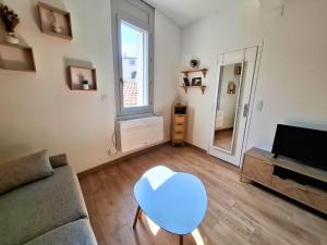 a living room with a couch and a table and a mirror at T2 Cosy Clim & WiFi - Ecusson cœur de Montpellier in Montpellier +13 photos