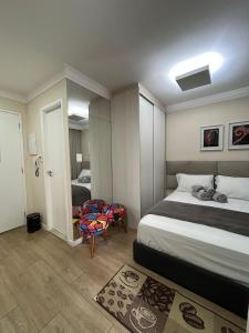 a bedroom with a bed and a room with a chair at Excelente Studio a 3 quadras da Avenida Paulista in Sao Paulo +21 photos