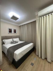 a bedroom with a large bed and curtains at Excelente Studio a 3 quadras da Avenida Paulista in Sao Paulo