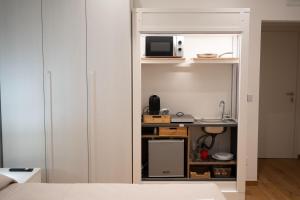 a room with a bed and a kitchen with a microwave at G&G Luxury Rooms in Bari