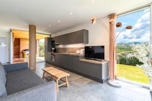 a kitchen and living room with a large window at Splendide appartement T3 piscine et vue mer in Grosseto-Prugna