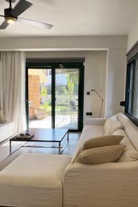a living room with two white couches and a table at Nikiti Blue house 30m from the beach with sea view in Nikiti