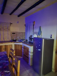 a kitchen with a stainless steel refrigerator and a table at Starehe Luxury B & B in Malindi