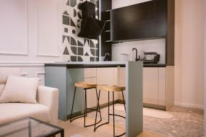 una cucina con un bancone e sgabelli in una stanza di SoulNest Apartments a Sarajevo