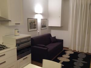 a living room with a purple couch in a kitchen at Le Stanze di Theia in Chianciano Terme