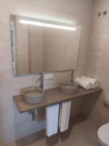 a bathroom with two sinks and a mirror and towels at Apartamento Nuevo Ondina in Begur +19 photos
