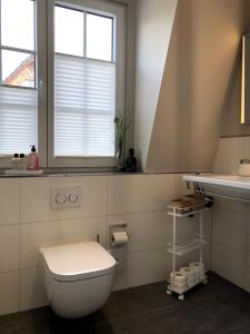 ein Badezimmer mit Toilette und Waschbecken und einem Fenster in der Unterkunft Ferienhaus Berg in Sylt + 44 Fotos