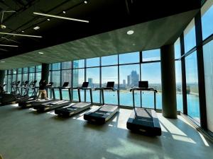 a gym with a row of treadmills in a building at Dreamy Sunsuria Forum Homes-Setia City Mall, Setia City Convention Centre and National Institute of Health in Shah Alam