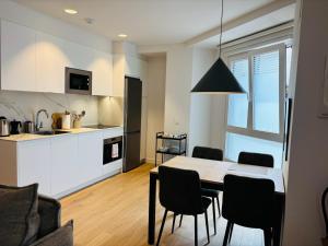 a kitchen and dining room with a table and chairs at Apartamentos DORRE LUZEA Apartamentuak in Zarautz