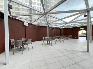 a room with chairs and tables and a glass ceiling at Dreamy Sunsuria Forum Homes-Setia City Mall, Setia City Convention Centre and National Institute of Health in Shah Alam