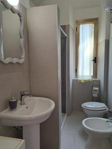 a bathroom with a sink and a toilet and a mirror at Casa Vacanze Tirreno in Santa Marinella +23 photos