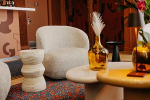 a living room with a chair and a table with vases at Residhome Nanterre La Défense in Nanterre +25 photos