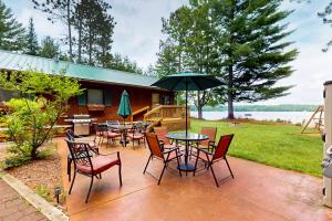 a patio with tables and chairs and an umbrella at Catfish Cottage B in Eagle River