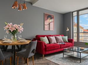 salon z czerwoną kanapą i stołem w obiekcie Classy Apartments - Ruska we Wrocławiu