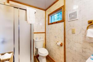 a bathroom with a toilet and a window at Catfish Cottage B in Eagle River +21 photos
