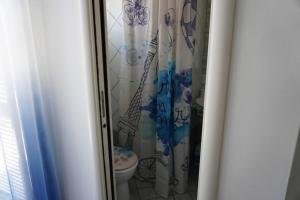 a bathroom with a shower curtain with a toilet at Villa 7 posti a 3 minuti dal mare - Villa Carbone in Sperlonga +35 photos