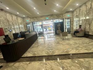 un homme assis sur une chaise dans un hall dans l'établissement Stay Inn AlBarsha by PHM, à Sabkhah 32 autres photos