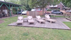 a patio with chairs and a table and a picnic table at Apartmenthaus am Nordseestrand, Whg 3, An der Rennweide 1B, 75qm in Dangast