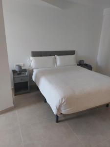 a bed with white sheets and pillows in a bedroom at Apartamento Nuevo Ondina in Begur