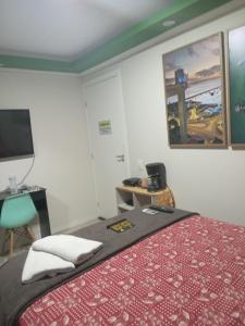 a bedroom with a bed and a desk and a television at Paraíso dos Viajantes - O PREFERIDO in Salvador