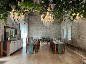 a dining room with tables and chairs and a chandelier at French Manor House with private gardens and pool in Foissac