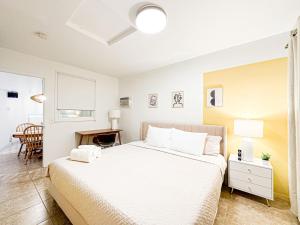 a bedroom with a large white bed and a desk at Relaxed and Cozy Poolside Studio - LOU2 - BUR in Burbank +8 photos
