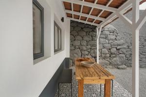 a wooden table in a room with a stone wall at The Village Loft in Caniço