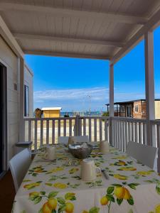 a table on a balcony with a view of the ocean at The Beach Camping Village in Marina di Carrara