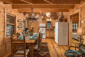 a dining room with a table and a refrigerator at Falcon Lodge - hot tub fire pit & games in Mentone