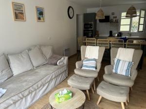 ein Wohnzimmer mit einer Couch und zwei Stühlen und einem Tisch in der Unterkunft Maison entierement rénovée à 10 mn de la plage in Dolus-d'Oléron