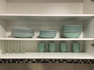 a row of plates and cups on a shelf at Depto calle huérfanos, Santiago in Santiago +6 photos