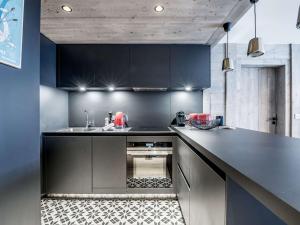 谷雪维尔Appartement au centre de Courchevel 1550, 6/7 pers, Wi-Fi, parking, accès spa - FR-1-631-198的厨房配有黑色橱柜和黑色台面 更多3张照片