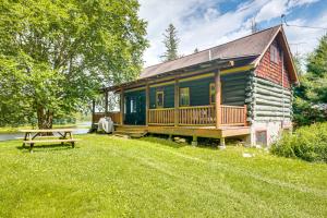 a log cabin with a wooden porch and a picnic table at Dock, Fire Pit Historic Lakefront Cabin in Mercer in Mercer