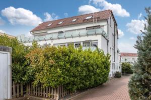 a white house with a fence and bushes at Schilfbrise in Wunstorf