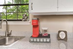 a red blender sitting on a counter next to a sink at Country Lane Cottage- privacy & quiet neighborhood in Rossville