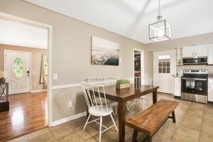 a kitchen and dining room with a wooden table and chairs at Country Lane Cottage- privacy & quiet neighborhood in Rossville +34 photos