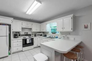 a kitchen with white cabinets and a white counter top at Covenant Cottage with outdoor dining in Lookout Mountain +33 photos