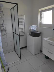 ein weißes Badezimmer mit Dusche und Waschbecken in der Unterkunft Maison 4 voyageurs proche circuit Mirecourt 