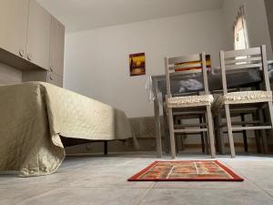 a room with a table and two chairs and a rug at La Depandance in Porto Cesareo