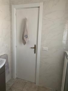 a white door in a bathroom with a sink at La Depandance in Porto Cesareo