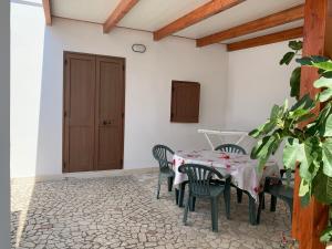 a dining room with a table and chairs and a door at La Depandance in Porto Cesareo +8 photos