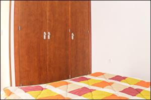 1 dormitorio con 1 cama y armario de madera en Apartamento Pascual Junquera II, en Conil de la Frontera