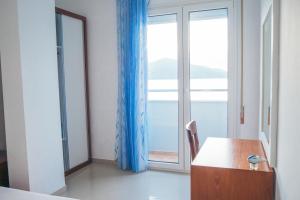 奥里库姆Blue Paradise Hotel的客房设有书桌和大窗户。