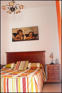 1 dormitorio con 1 cama y una pintura en la pared en Apartamento Pascual Junquera II, en Conil de la Frontera